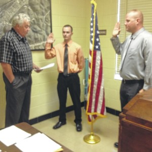 Submitted photo New Boston Mayor Junior Williams (left) administers the oath of office to two new New Boston police officers. They are Bryan Charles Jordan (middle) and Nickolas James Shepherd (right).